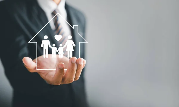 Nurturing family connections, Businessman protective gesture resonates with young family silhouette. Health and house insurance icons emphasize safety and care, reinforcing support.