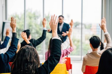 İş adamları bir konferans ve kongrenin yer aldığı bir şirket etkinliği için bir araya geliyorlar. Kaldırılan eller, bir toplantı eğitim semineri ve tartışmalarında aktif rol oynadığını gösteriyor.