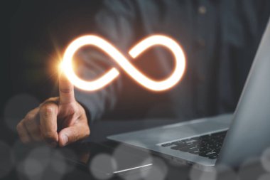 İş adamı veri teknolojisindeki sınırsız bağlantıyı sembolize ederek dikkatleri sonsuzluk sembolüne yöneltir. Siber uzay, gelecek sınırsız. Sonsuz güç, enerji, internet bilgileri. teknoloji sonsuzluk
