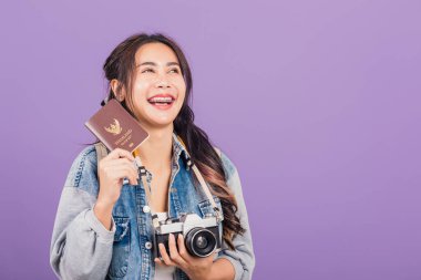 Mutlu bir Asyalı portresi güzel bir kadın. Yaz tatilinde gülümseyen bir kadın. Elinde pasaport ve klasik fotoğraf makinesi olan Taylandlı bir kadın.