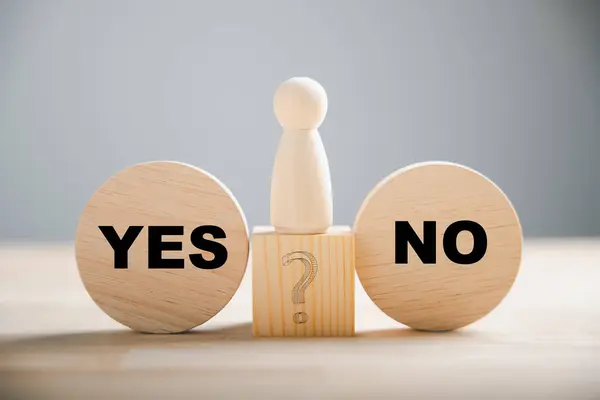 Wooden block choice showcases peoples conflict between right and wrong contemplating yes or no decisions. True and false symbols on wood illustrate business dilemmas. Think With Yes Or No Choice.