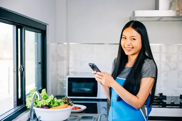 Cozy Kitchen Asian Woman Cooks Vegetables Viewing Cooking Tutorial Her — Stock Photo, Image