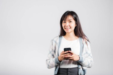 Heyecanlı bir kadın akıllı telefon stüdyosunda izole edilmiş beyaz arka planda sosyal ağ geribildirimi okudu, sosyal medyada SMS yazan genç bir kadın.