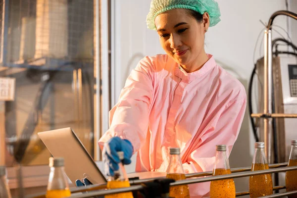 Female Manufacturer Inspects Beverage Bottles Factory Conveyor Belt Utilizing Laptop — Stock Photo, Image