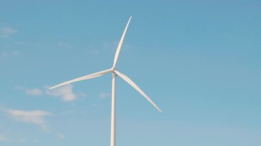 Doğa verimliliği gösteriliyor, dağdaki yel değirmeni tarım türbinleri temiz elektrik üretiyor. Mavi gökyüzü altında sürdürülebilir gelişimi destekleyen yenilikçi teknolojinin sembolü..