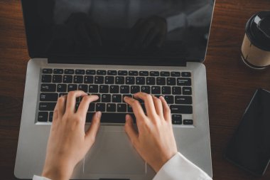 Dizüstü bilgisayarda klavye yazan, ofis dışında online çalışan Asyalı genç iş kadını yaşam tarzı kafeteryada dizüstü bilgisayar kullanan mutlu bir serbest yazar.