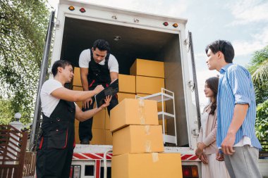 Mutlu yeni evli çift, profesyonel nakliyeciler tarafından taşınan mobilyaların dağıtım listesi. Çalışan takım çalışması müşteri memnuniyetini sağlar. Taşınma Günü Kavramı