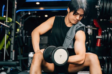 Erkeklik ve sağlık kavramı - halter ve egzersizlerde vücudunun gücünü ve gücünü gösteren ağır bir dambıl tutan kaslı bir adam. boş boşluk