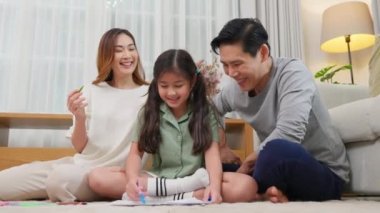 Asyalı bir aile, oturma odasında küçük bir kız çocuğuyla resim yaparken, mutlu bir baba ve kızı, evde kağıt üzerine resim çizerken, aile aktivitelerini severken,