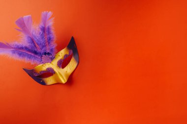 Happy Purim carnival. Carnival mask for Mardi Gras celebration isolated on red background with copy space, jewish holiday, Purim in Hebrew holiday carnival ball, Venetian mask, masquerade accessory