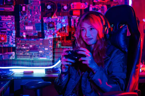 女性は自宅でライブストリームEsportsゲームコンソールを再生ゲームヘッドフォンを着用し ゲーマーは 仮想トーナメントのためのジョイスティックコントローラを使用してコンピュータネオンライトでオンラインビデオゲームをプレイ — ストック写真