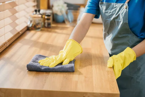 現代の台所の主婦かメイドは食卓の表面を拭きます 家庭の整頓のための専門のクリーニングプロダクトを使用して 作業安全グローブ衛生ルーチンでクリーナー メイドハウスキーピングのコンセプト — ストック写真