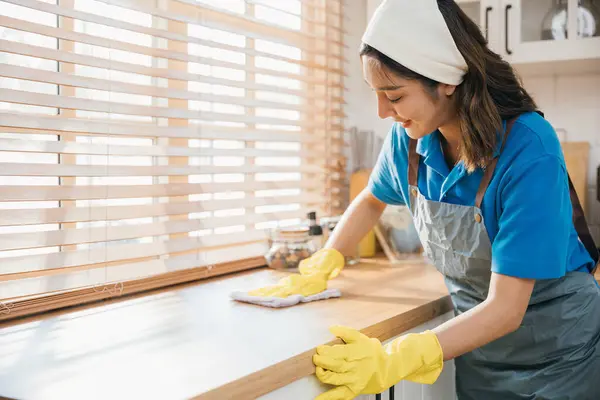 Aziatische Vrouw Gele Handschoenen Reinigt Houten Aanrecht Met Vloeibare Spray — Stockfoto
