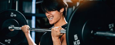 Formda ve kaslı vücutlu, ağırlık kaldıran ve spor salonunda egzersiz yapmak için halter tutan güçlü bir adam. Güç kaldırma eğitim kavramı