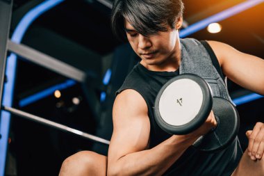 Elinde dambıl tutan ince ve tonlu bir adam sağlıklı ve aktif bir yaşam tarzının faydalarını ve günlük hayatta spor ve spor yapmanın önemini sergiliyor. boş boşluk