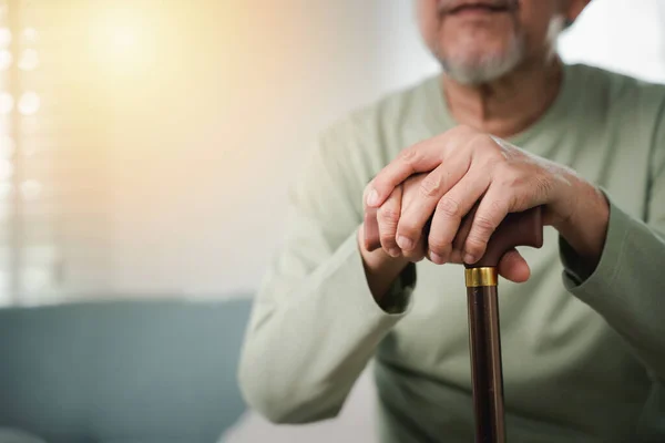 Bliższe Ręce Starszego Niepełnosprawnego Trzymającego Laskę Starca Siedzącego Kanapie Drewnianą — Zdjęcie stockowe