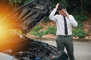 Araç bozulduktan sonra, şoför yol yardımı ile telefonda konuşuyor. Otoyolda duran işadamı, açık kaputla internet bağlantısını kontrol ediyor. Ulaşım sorunları için kavram