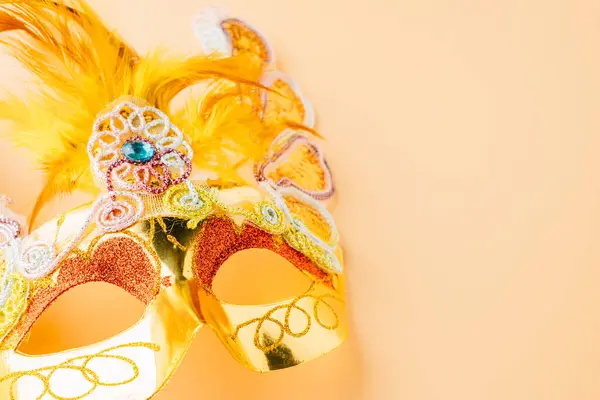 Happy Purim carnival decoration. Golden venetian ball mask, carnival mask isolated on pastel background, Purim or Mardi Gras in Hebrew, Masquerade party event