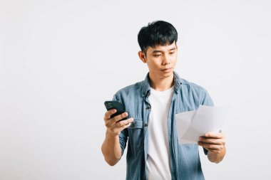 Beyazlar içinde soyutlanmış genç bir adam, elinde faturalar, bir belge ve bir cep telefonu tutuyordu. Finansal evrak işlerinde çalışırken yaşadığı mali stres ve depresyonu yansıtan bir yüz ifadesi vardı..