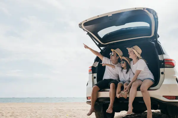家族の日だ 母と娘は車の後ろに座って青い空を指差す道路旅行を楽しんで ビーチで夏休みを楽しんでいる幸せな人々 海のビーチでの休日の家族旅行 — ストック写真