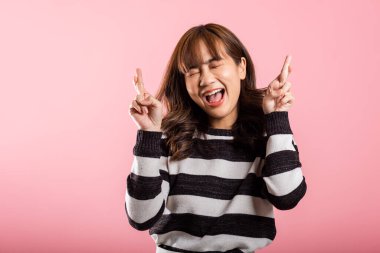Asyalı mutlu bir portre güzel güzel bir kadın gülümsemesi iyi şans için parmaklarını çapraz tutar ya da yalan jest stüdyosu çekilir pembe arka planda izole edilmiş genç kadın sahtekarlığı umutları daha iyi olur