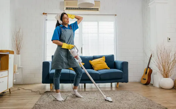 Happy maids cleanup melody, Asian woman uses mop as mic singing dancing. Fun-filled service with music laughter and excitement. Modern domestic joy. Give me a beat, maid dancing having fun