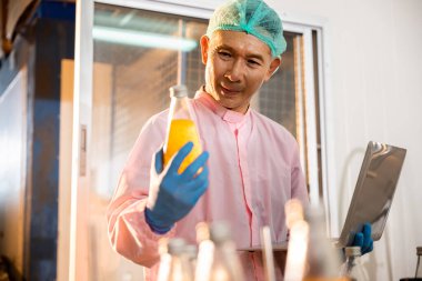 Mühendis, içki imalatında yüksek standartları korumak için müfettişle işbirliği yapıyor. Makineleri ve üretim hattını kontrol edip yüksek kalitede üretim sağlıyorlar..