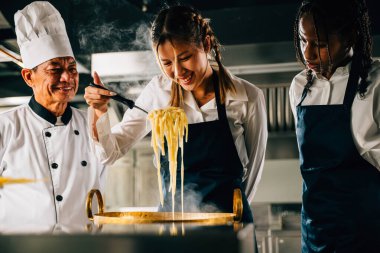 Mutfakta şef öğrencilere ders veriyor. Öğrenci kızlar ramen yapar. Çocuklar ve öğretmen ocakta. Öğrenmenin gülümseyen portresi modern eğitimdir. Kepçeyle yemek yapmak keyiflidir. Foor Eğitim Konsepti