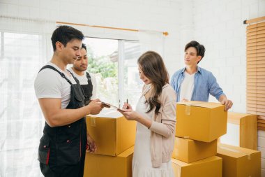 Aile teftişleri kontrol listesi çalışanı bir teslimat kutusu tutuyor. Profesyonel nakliyeciler başarılı bir ev yerleştirme garantisi veriyor. Takım çalışması ve etkili hareket görüntülendi. Yeni Eve Taşınma Günü