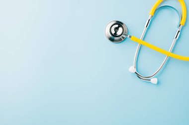 Üst görünüm sarı tıbbi steteskop mavi arka planda sizin için metin, doktor ekipmanı, sağlık ve sağlık hizmetleri, Doktor Günü ve Dünya Kanser Günü konsepti ile izole edildi.