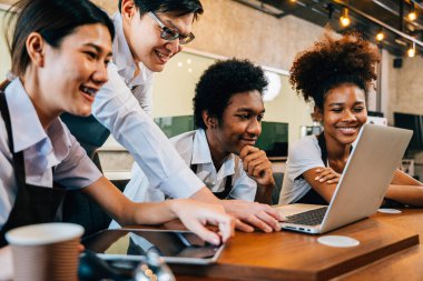 Kahve dükkanının sahibi ve genç iş adamları dizüstü bilgisayarla proje üzerinde çalışıyorlar. Girişim takım çalışması konsepti meslektaşları başarı için birlikte beyin fırtınası planlıyorlar..