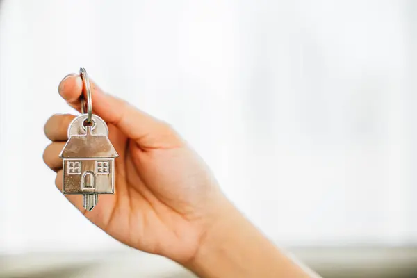 A female hand with a house key symbolizing confidence and success in homeownership. Reflecting happiness achievement and the excitement of a new investment.