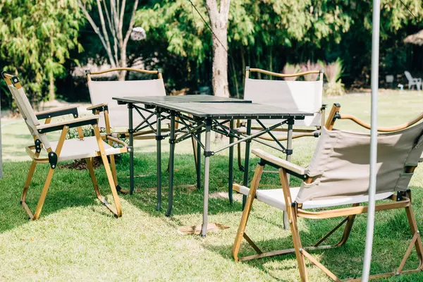 An outdoor picnic in the summer with a camping tent, tables, and chairs, set in the suburban patio. Enjoy the comfort and shade while celebrating outdoors in this relaxing environment.