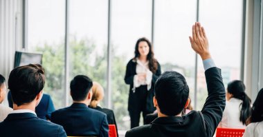 Bir grup içinden bir kişi aktif katılım takım çalışması ve tartışmalara katılma isteğini gösteren bir konferansta el kaldırdı.