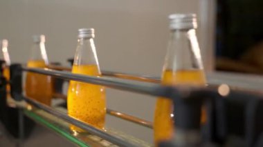Fabrikalar temiz otomatik işlemler şeffaf şişeleri organik fesleğen veya nar ile karıştırılmış chia tohumu içecekleriyle doldurur. Sonuçta yüksek kaliteli imalat açıkça görülüyor.