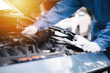 Asyalı tamirci garajdaki araba motoru ile ilgili bir liste yapıyor. Otomobil tamiri ve güvenlik ve bakım konusunda uzmanım. Teknisyenlerin meydan okuması, güvenliğin sağlanması, güvenle gülümseme..