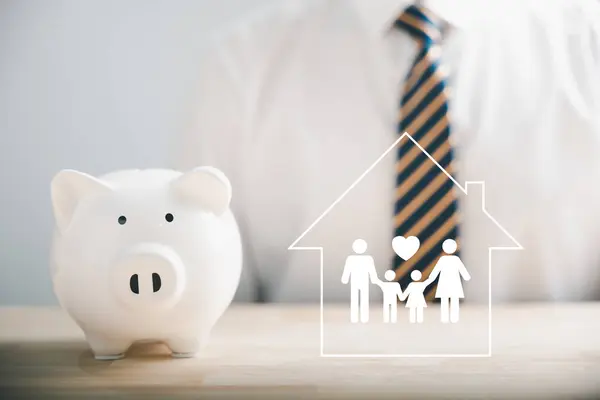 Businessman protects piggybank, holds family icon in hand, symbolizing saving, donation, family finance strategies. Depicting mes of charity, fundraising, superannuation, and financial crisis concept.