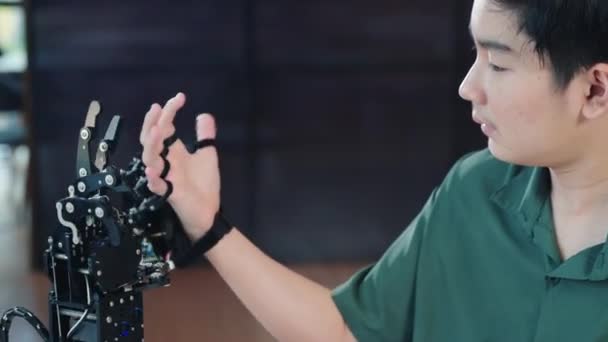 Szczęśliwy Azjatycki Nastolatek Uczy Się Technologii Testując Rękę Robota Ramię — Wideo stockowe