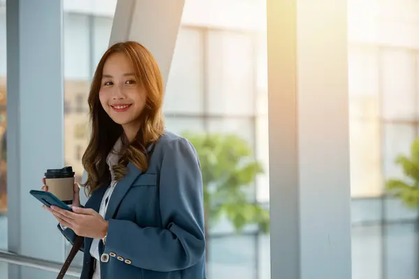 Asiatisk Kvinna Rulltrappan Håller Varm Kopp Kaffe Och Smartphone Perfekt Stockbild