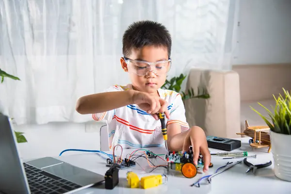 Asian Kid Boy Assembling Arduino Robot Car Homework Project Home Royaltyfria Stockfoton