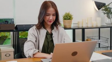 Ofiste dizüstü bilgisayarda çalışan güzel bir kadının portresi, gülümseyen bir iş kadını sabahları dizüstü bilgisayarda klavye kullanarak oturuyor, online alışveriş satışlarını kontrol ediyor.