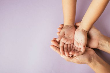 Ebeveyn ve çocuğun renkli bir arka planda el ele tutuşması. Aile Günü birliktelik ve desteği kutluyor..
