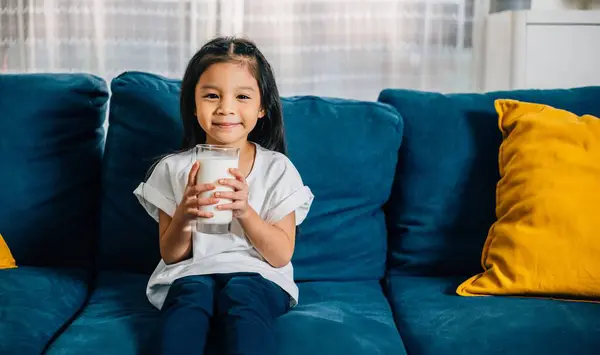 Adorable Asian Child Enjoys Glass Milk Comfy Sofa Home Radiating Stok Gambar