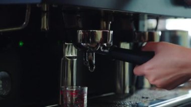 Kahve dükkanında espresso makinesi kahve yapar. Kadehlere espresso dökmek kafedeki modern teknolojiyi ortaya çıkarıyor. Akıcı sıvı buhar, şeffaf cam bardaklar..