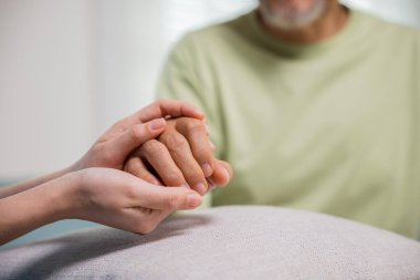Yaşlılar için Uluslararası Gün. Yaşlı adam bakım tesisine yardım eden bakıcı hastaneden yardım alıyor. Genç bir kadın yaşlı bir adama yardım eli uzatıyor.