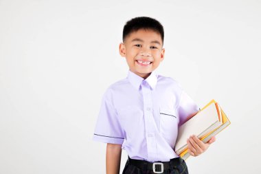 Portre gülümsemesi Asyalı küçük çocuk el pozu veriyor kitap stüdyosu izole edilmiş beyaz arka plan, mutlu sevimli çocuk okul üniforması giyiyor, okula geri dönüyor.