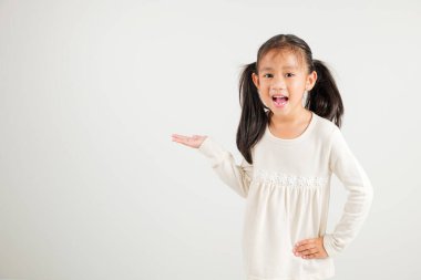 Asyalı mutlu bir genç kız gülümsemesi. Ürünü avucunun içinde taşıyor. Stüdyo resmi beyaz arka planda, fotokopi alanı ile izole edilmiş.