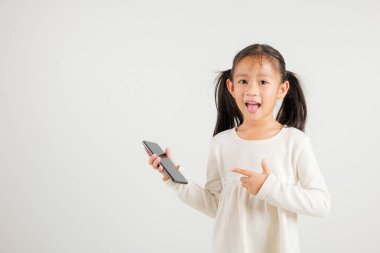 Asyalı mutlu genç kız gülümsemesi ekrandaki akıllı telefonu işaret ediyor, anaokulu çocukları internetten alışveriş yapıyor izole edilmiş stüdyo görüntüleri beyaz arka plan.