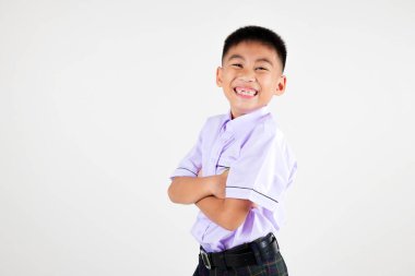 Gülümseyen Asyalı küçük çocuk kollarını kavuşturmuş poz veriyor izole edilmiş beyaz arka plan, mutlu tatlı çocuk okul üniforması giyiyor çapraz kollar, okula dönüş konsepti.