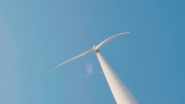 Bir dağdaki yel değirmeni tarım türbinlerinin sakin manzarası temiz enerji yeniliğini gösteriyor. Modern teknoloji sonsuz mavi gökyüzü altında sürdürülebilir gelişimi destekler..